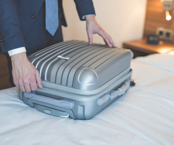 Young businessman with a suitcase in the room